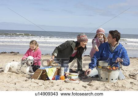 Stock Image - Family Having Barbeque On Winter Beach. Fotosearch