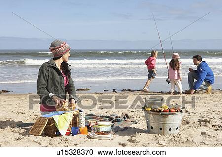 Stock Image - Family Having Barbeque On Winter Beach. Fotosearch