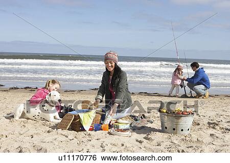 Stock Photograph - Family Having Barbeque On Winter Beach. Fotosearch