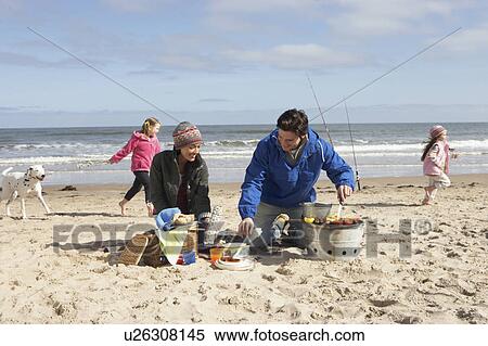 Stock Photography - Family Having Barbeque On Winter Beach. Fotosearch