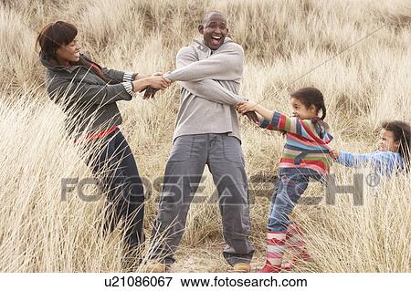 Stock Photo - Family Having Fun In Sand Dunes. Fotosearch