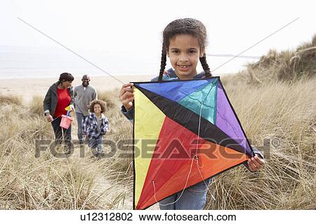 Stock Image - Family Having Fun With Kite In Sand Dunes. Fotosearch