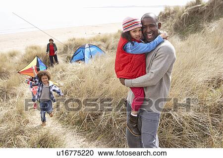 Stock Image - Family Having Fun With Kite In Sand Dunes. Fotosearch