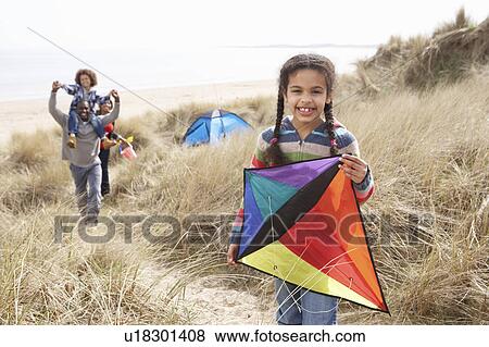 Stock Photo - Family Having Fun With Kite In Sand Dunes. Fotosearch