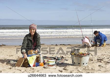 Stock Image - Family Having Picnic On Winter Beach. Fotosearch