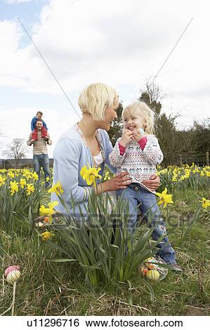 Stock Photograph - Family On Easter Egg Hunt In Daffodil Field. Fotosearch