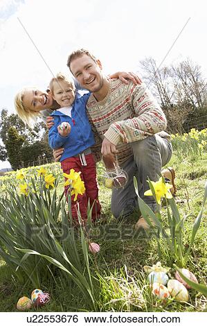 Stock Photograph - Family On Easter Egg Hunt In Daffodil Field. Fotosearch