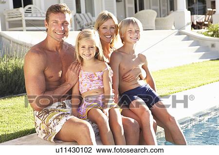Stock Image - Family Outside Relaxing By Swimming Pool. Fotosearch