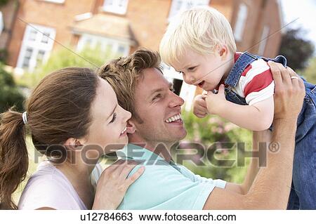 Stock Image - Family Playing Together In Garden At Home. Fotosearch