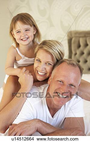 Family Relaxing In Bedroom View Large Photo Image Picture - Family Relaxing In Bedroom. Fotosearch