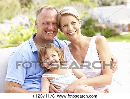 Stock Photo - Family Relaxing In Garden. Fotosearch