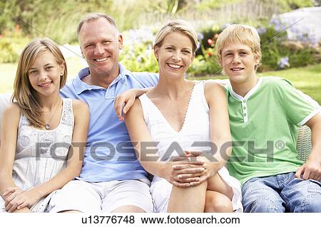 Stock Photo - Family Relaxing In Garden. Fotosearch