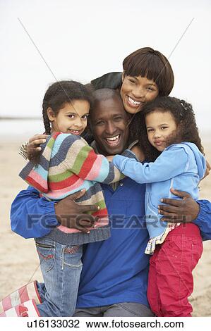 Stock Image - Family Relaxing On Winter Beach Break . Fotosearch