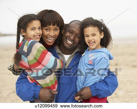 Stock Photo - Family Relaxing On Winter Beach Break . Fotosearch