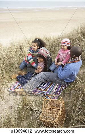 Family Sitting In Dunes Enjoying Picnic On Winter Beach View Large Photo Image Stock Image - Family Sitting In Dunes Enjoying Picnic On Winter Beach. Fotosearch