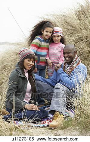 Family Sitting In Dunes Enjoying Picnic On Winter Beach View Large Photo Image Stock Photography - Family Sitting In Dunes Enjoying Picnic On Winter Beach. Fotosearch
