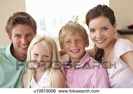 Stock Photograph - Family Sitting On Sofa At Home Together. Fotosearch