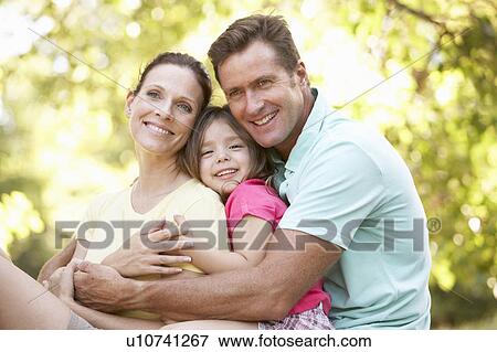Stock Photo - Family Sitting On Tree In Park. Fotosearch