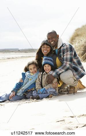 Stock Photo - Family Sitting On Winter Beach. Fotosearch
