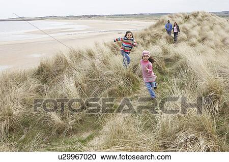 Family Walking Along Dunes On Winter Beach View Large Photo Image Stock Image - Family Walking Along Dunes On Winter Beach. Fotosearch