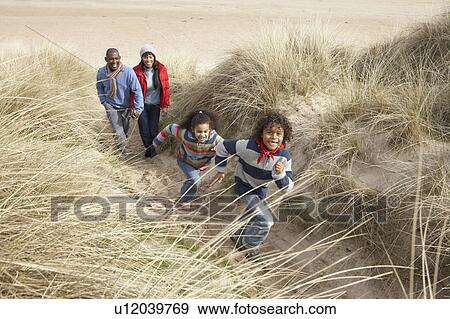 Stock Photo - Family Walking Along Dunes On Winter Beach. Fotosearch