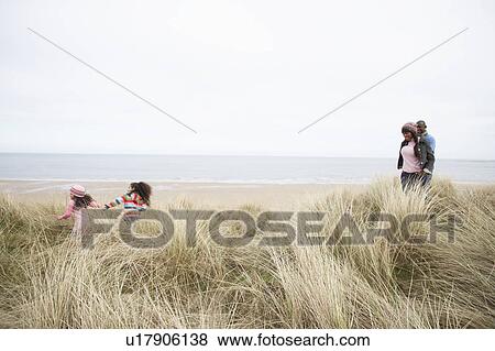 Stock Photo - Family Walking Along Dunes On Winter Beach. Fotosearch