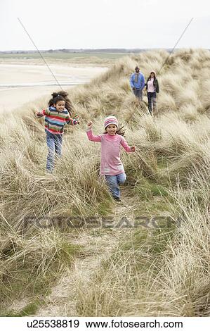 Stock Photo - Family Walking Along Dunes On Winter Beach. Fotosearch