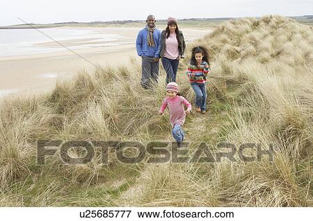 Stock Photo - Family Walking Along Dunes On Winter Beach. Fotosearch