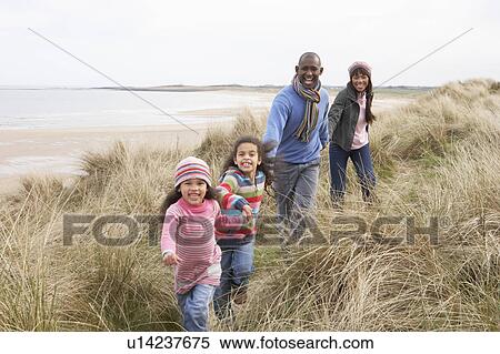Stock Photography - Family Walking Along Dunes On Winter Beach. Fotosearch
