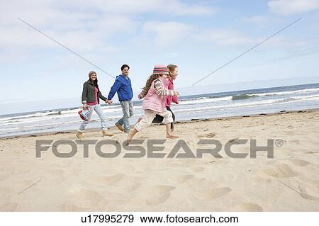 Stock Photo - Family Walking Along Winter Beach. Fotosearch