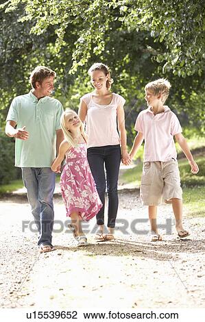 Stock Image - Family Walking In Countryside Together. Fotosearch