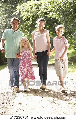 Stock Image - Family Walking In Countryside Together. Fotosearch