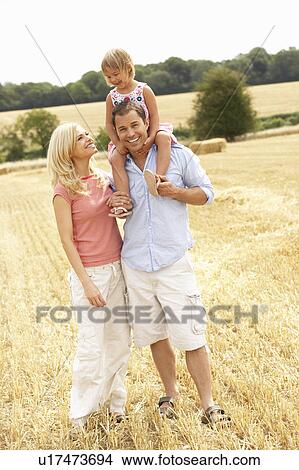 Picture - Family Walking Together Through Summer Harvested Field. Fotosearch