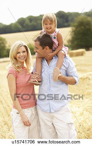 Stock Photograph - Family Walking Together Through Summer Harvested Field. Fotosearch