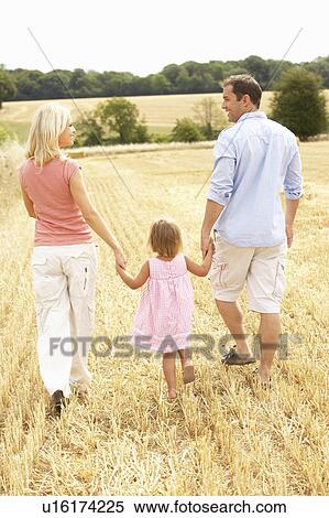 Stock Photography - Family Walking Together Through Summer Harvested Field. Fotosearch