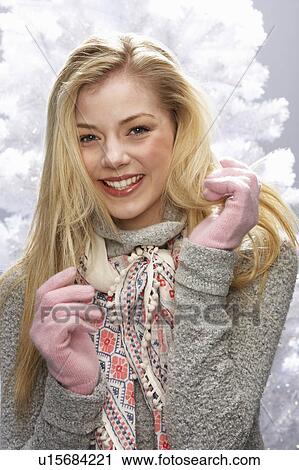 Stock Image - Fashionable Teenage Girl Wearing Cap And Knitwear In Studio In Front Of Christmas Tree. Fotosearch