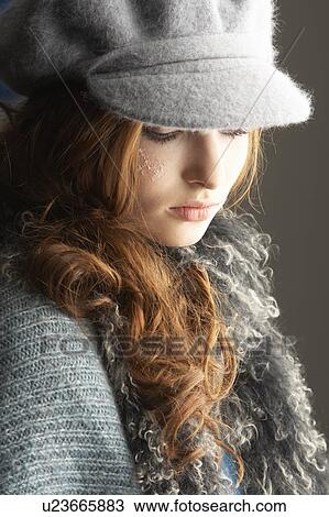 Stock Image - Fashionable Teenage Girl Wearing Cap And Knitwear In Studio. Fotosearch