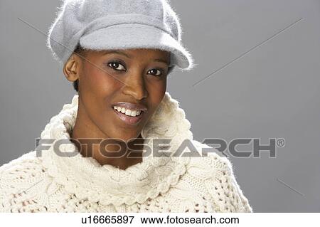 Stock Photo - Fashionable Woman Wearing Knitwear And Cap In Studio. Fotosearch