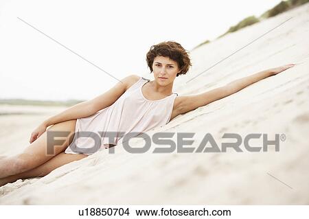 Fashionably Dressed Attractive Young Woman Laying Amongst Sand Dunes View Large Photo Image Picture - Fashionably Dressed Attractive Young Woman Laying Amongst Sand Dunes. Fotosearch