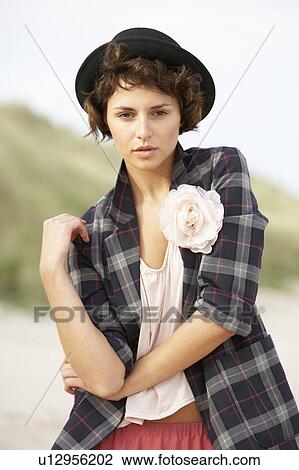 Stock Image - Fashionably Dressed Attractive Young Woman Standing Amongst Sand Dunes. Fotosearch