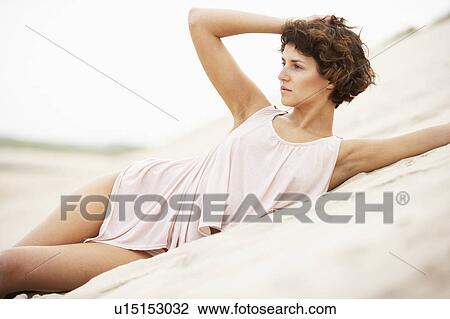 Fashionably Dressed Attractive Young Woman Laying Amongst Sand Dunes View Large Photo Image Stock Image - Fashionably Dressed Attractive Young Woman Laying Amongst Sand Dunes. Fotosearch