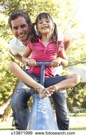 Father And Daughter Riding On See Saw In Playground View Large Photo Image Stock Photo - Father And Daughter Riding On See Saw In Playground. Fotosearch