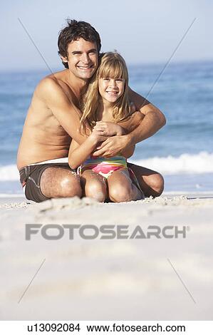 Father And Daughter Wearing Swimwear Sitting On Sandy Beach View Large Photo Image Picture - Father And Daughter Wearing Swimwear Sitting On Sandy Beach. Fotosearch