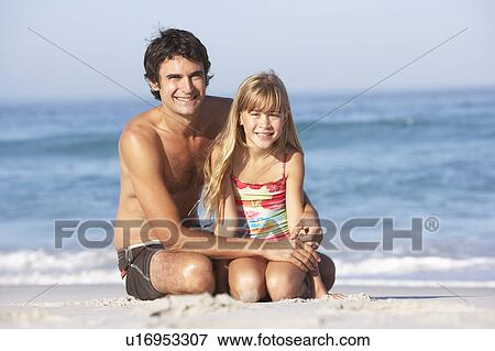 Father And Daughter Wearing Swimwear Sitting On Sandy Beach View Large Photo Image Stock Photo - Father And Daughter Wearing Swimwear Sitting On Sandy Beach. Fotosearch