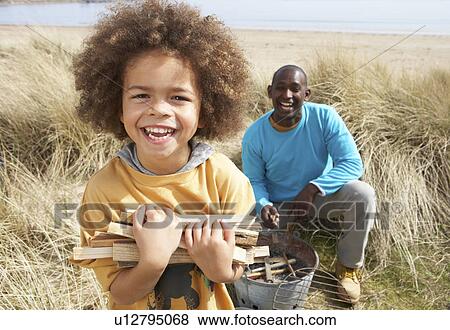 Father And Son Collecting Firewood On Beach Camping Holiday View Large Photo Image Stock Photo - Father And Son Collecting Firewood On Beach Camping Holiday. Fotosearch