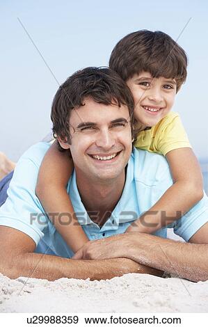 Father And Son Relaxing On Beach Holiday View Large Photo Image Stock Photo - Father And Son Relaxing On Beach Holiday. Fotosearch