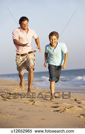 Stock Photography - Father And Son Running Along Summer Beach. Fotosearch