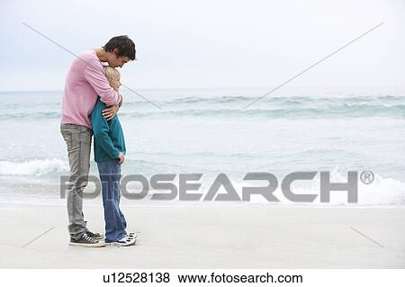 Stock Photo - Father And Son Standing On Winter Beach Together. Fotosearch