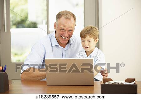 Father And Son Using Laptop At Home View Large Photo Image Stock Photo - Father And Son Using Laptop At Home. Fotosearch