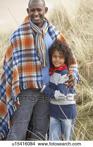 Father And Son Wrapped In Blanket Amongst Dunes On Winter Beach View Large Photo Image Picture - Father And Son Wrapped In Blanket Amongst Dunes On Winter Beach. Fotosearch